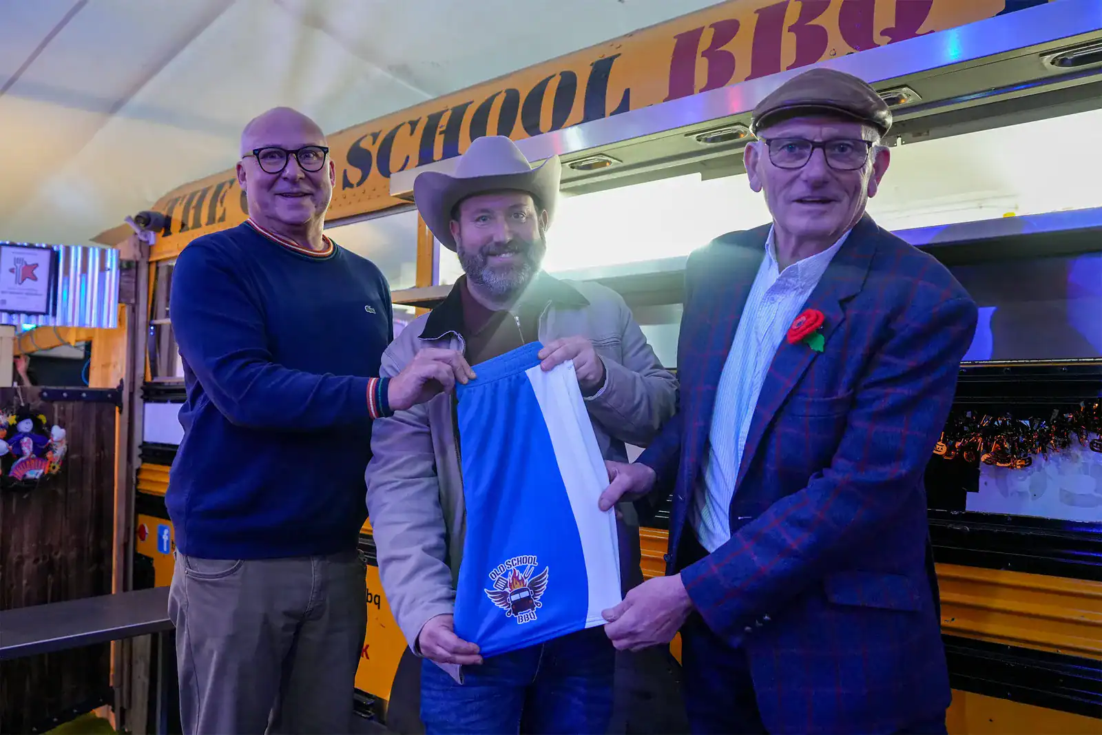 2024-25-Good-Food-Awards-Coming-Soon-4-November-2024 Mark Smith, Mark Fairley and Frank Rothwell hold up a pair of Oldham Athletic shorts sponsored by Old School BBQ